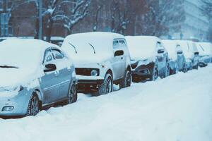 cars are parked along the roads covered in snow photo