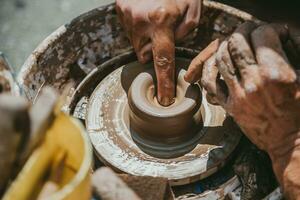 Master hands makes a pot of clay. Master class is held in nature, close-up photo