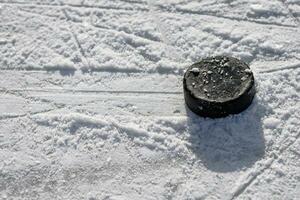 hockey puck lies on the ice in the stadium photo