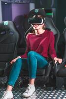 beautiful girl in virtual glasses is watching a movie with special effects in 5d photo