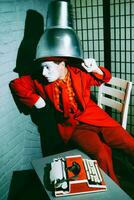 Mime put a metal lampshade on his head, makes faces and poses photo