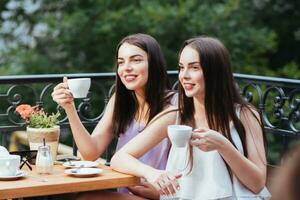 Girlfriends are sitting in coffee and drinking tea photo