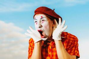 Mime shows pantomime against the blue sky photo