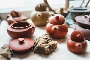 ceramic teapots stand on a window in a cafe photo