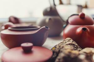 ceramic teapots stand on a window in a cafe photo