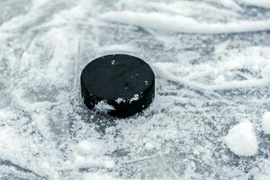 hockey puck lies on the snow close-up photo