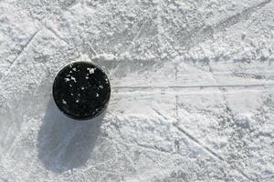 hockey puck lies on the ice in the stadium photo