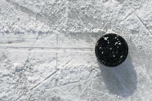 hockey puck lies on the ice in the stadium photo