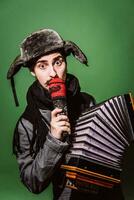 a very positive man with an accordion posing in the studio photo