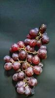 Portrait top view of vitis vinifera fruits isolated on a black background photo