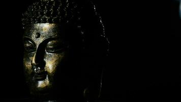 Buddha face, deity buddhist, rotating at black background justify at left video