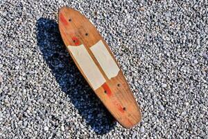 a wooden skateboard laying on the ground photo