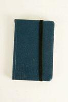 a blue notebook with black binding on a white surface photo