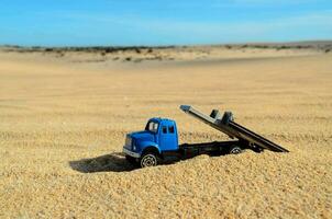 a toy truck is parked in the sand photo