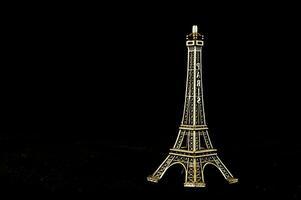 a gold eiffel tower on a black background photo