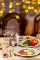 servido festivo mesa con aperitivos, anteojos, anteojos, cuchillería y servilletas para un banquete foto