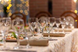 servido festivo mesa con aperitivos, anteojos, anteojos, cuchillería y servilletas para un banquete foto