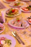 servido festivo mesa con aperitivos, anteojos, anteojos, cuchillería y servilletas para un banquete foto