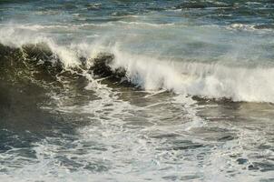 a man is riding a wave on a surfboard photo