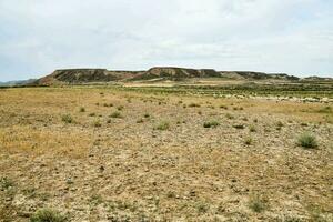 a dry desert with a mountain in the background photo