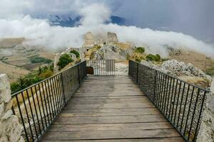 a wooden walkway leads to a castle in the clouds photo