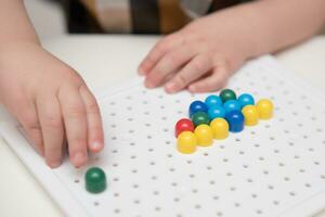 the baby plays with a mosaic sitting at a table photo