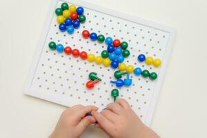 the baby plays with a mosaic sitting at a table photo