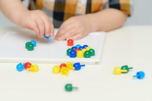 the baby plays with a mosaic sitting at a table photo