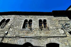 a stone building with windows and a blue sky photo