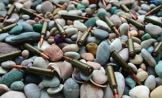 Bullets Scattered On A Pebble Stones Texture Background Stock Photo