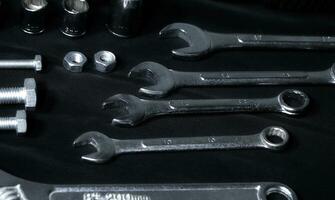 Open End Wrenches And Hardware Items Laid Out On Black Fabric photo
