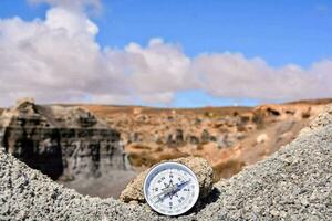 a compass is sitting on top of a rock photo