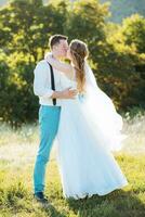 the bride and groom kissing at sunset photo