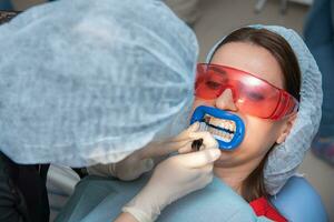 Preparing the oral cavity for whitening with an ultraviolet lamp. Close-up photo