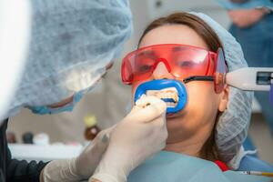 Preparing the oral cavity for whitening with an ultraviolet lamp. Close-up photo