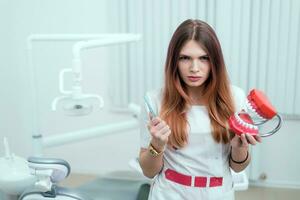 a strict view of a doctor orthodontist with a brush and teeth photo