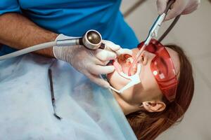 médico ortodoncista realiza un procedimiento para limpieza dientes foto