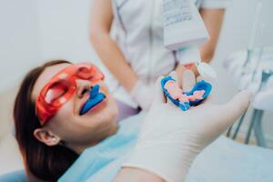 doctor orthodontist performs a procedure for cleaning teeth photo