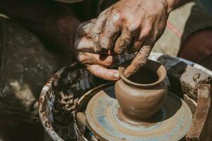 Master hands makes a pot of clay. Master class is held in nature, close-up photo