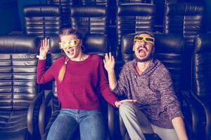 guy and girl 3d glasses are very worried while watching a movie in a cinema photo