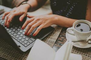 business woman in coffee prints on a laptop close-up photo