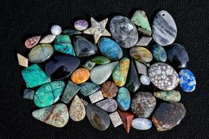 a pile of colorful stones on a black cloth photo