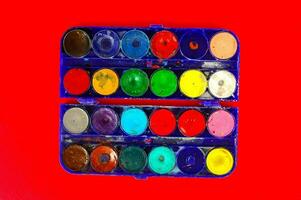 watercolor paint set on a red background photo
