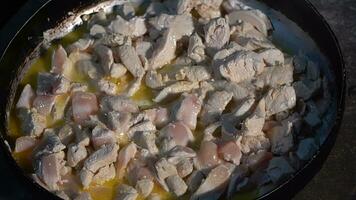 Preparation of chicken soup in a frying pan, close-up photo