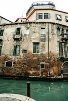 a building with windows and balconies on the side of a canal photo