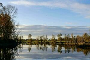 a river with trees and sky reflected in it photo