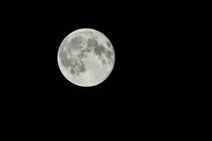 the moon is seen in the dark sky photo