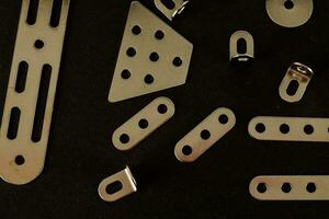 a variety of metal clips on a black surface photo