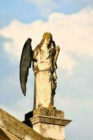 an angel statue on top of a building with a cloudy sky photo