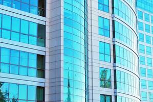 Structural glass wall reflecting blue sky. Abstract modern architecture fragment photo